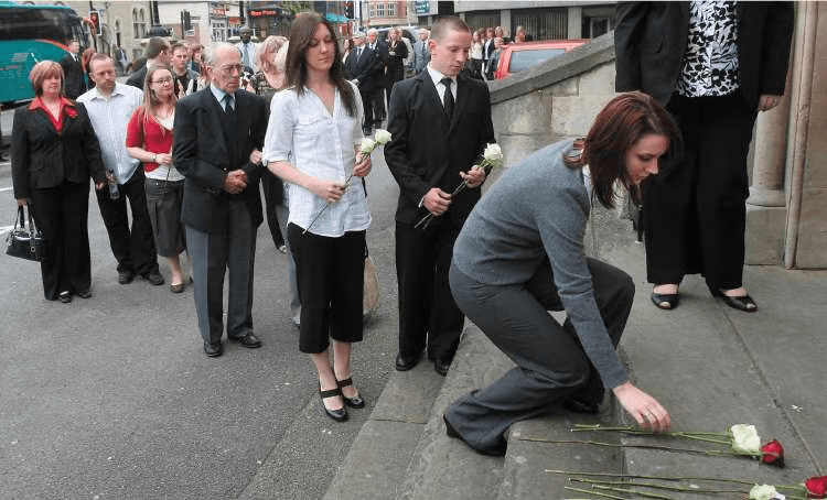 The families of those killed in the Nimrod tragedy lay flowers on the way into the Coroner's Court